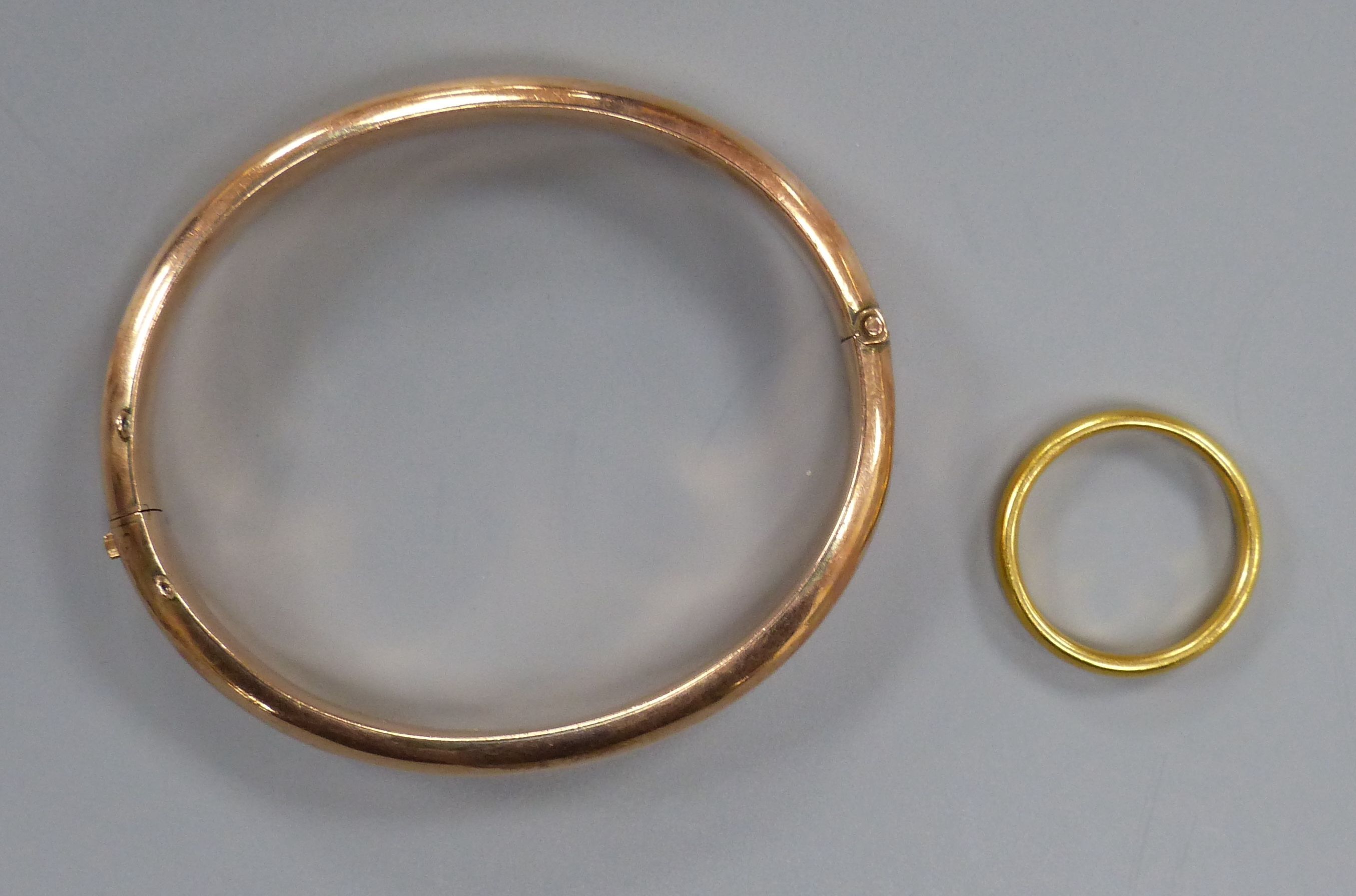 An 18ct gold wedding band, 6.1 grams and a 9ct gold hinged bangle, 12.3 grams.
